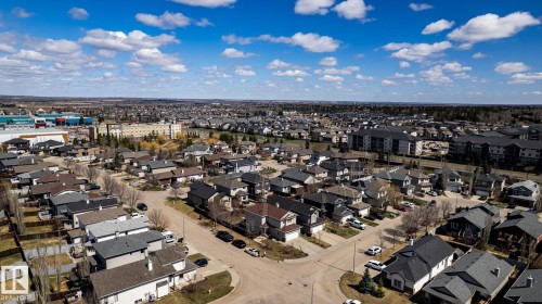 Expansive aerial view showcasing a developed residential neighborhood with a mix of single-family homes and multi-story apartment buildings - 55 Lamplight Cove, Spruce Grove, AB - Outdoor With View