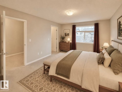 Carpeted bedroom with a large window, flush mount lighting, and white baseboards - 97 465 Hemingway Road, Edmonton, AB - Indoor Photo Showing Bedroom