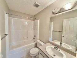 Bathroom featuring a white tub/shower combination, a vanity with an integrated sink, a large wall mirror, and a ceiling-mounted light fixture - 