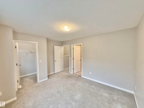 Spacious room featuring neutral carpeting, light gray wall paint, and white trim - 97 465 Hemingway Road, Edmonton, AB - Indoor Photo Showing Other Room