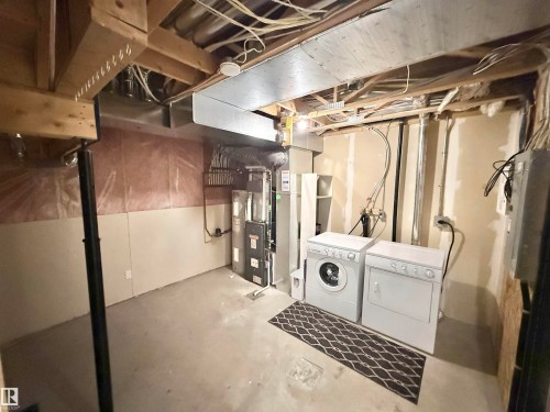 Unfinished basement featuring exposed wood joists and concrete flooring - 97 465 Hemingway Road, Edmonton, AB - Indoor Photo Showing Laundry Room