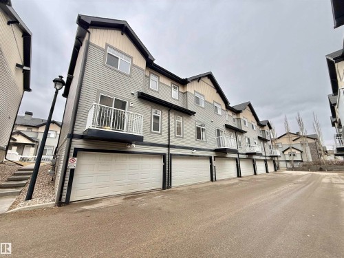 Multi-level townhome featuring gray and cream siding with dark trim accents - 97 465 Hemingway Road, Edmonton, AB - Outdoor