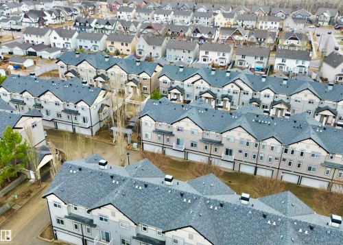 Rows of townhomes featuring multi-tone siding, dark shingled roofs, and private balconies - 97 465 Hemingway Road, Edmonton, AB - Outdoor
