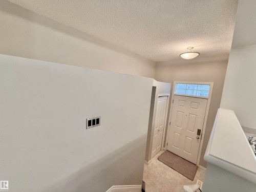 Entryway featuring a paneled door with transom window, overhead flush-mount lighting, and tile flooring - 97 465 Hemingway Road, Edmonton, AB - Indoor Photo Showing Other Room