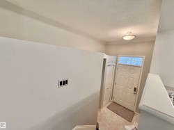 Entryway featuring a paneled door with transom window, overhead flush-mount lighting, and tile flooring - 