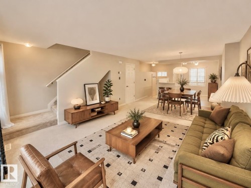 Open-concept living area featuring a carpeted staircase and neutral wall tones - 97 465 Hemingway Road, Edmonton, AB - Indoor Photo Showing Living Room