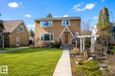 Stucco exterior featuring a prominent gabled entry with a solid wood front door - 11516 72 Avenue, Edmonton, AB  - Outdoor With Facade 