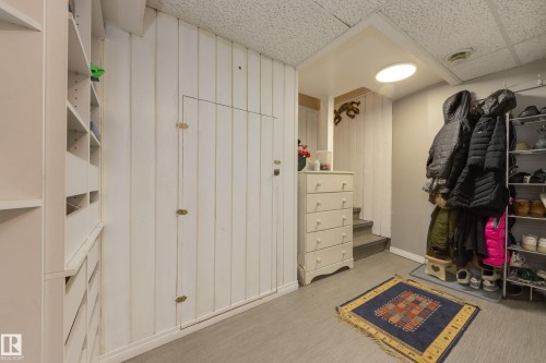 Built-in shelving and cabinetry against vertical plank wall paneling - 11516 72 Avenue, Edmonton, AB - Indoor
