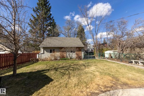 Generous backyard with a detached structure featuring horizontal siding and a shingle roof - 11516 72 Avenue, Edmonton, AB - Outdoor