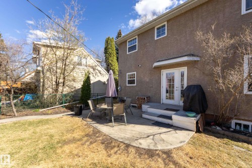 Rear exterior featuring a concrete patio, double white French doors, and two-tier exterior steps - 11516 72 Avenue, Edmonton, AB - Outdoor With Exterior