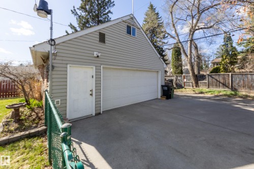 Detached two-car garage with light gray siding and a white paneled door - 11516 72 Avenue, Edmonton, AB - Outdoor