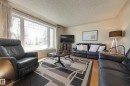 Spacious living area featuring large picture windows, light wood-finish flooring, and a textured ceiling - 11516 72 Avenue, Edmonton, AB  - Indoor Photo Showing Living Room 