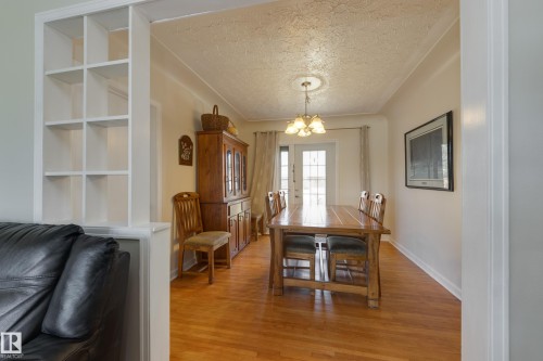 Dining area featuring wood-finish flooring and a central chandelier - 11516 72 Avenue, Edmonton, AB - Indoor Photo Showing Dining Room