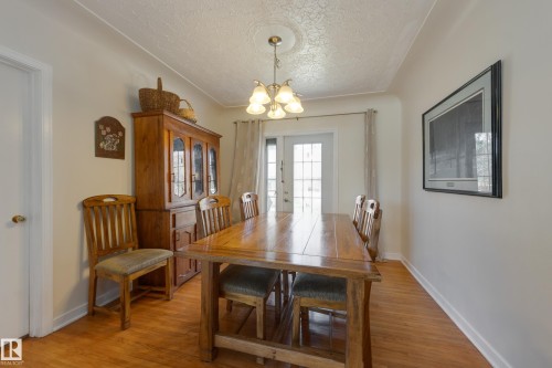 Dining area featuring wood-finish flooring, a decorative ceiling medallion, and a multi-bulb chandelier - 11516 72 Avenue, Edmonton, AB - Indoor Photo Showing Dining Room