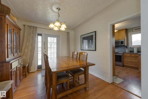 Warm-toned wood-finish flooring extends throughout this room - 11516 72 Avenue, Edmonton, AB - Indoor Photo Showing Dining Room