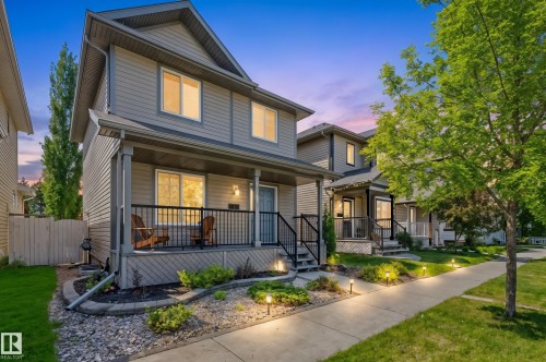 Two-story residence featuring horizontal siding and a covered front porch with black railings - 7641 Schmid Crescent, Edmonton, AB - Outdoor With Deck Patio Veranda With Facade