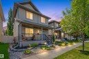 Two-story residence featuring horizontal siding and a covered front porch with black railings - 7641 Schmid Crescent, Edmonton, AB  - Outdoor With Deck Patio Veranda With Facade 