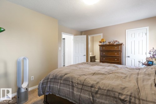 Carpeted room featuring neutral-toned walls, white trim, and a textured ceiling - 7641 Schmid Crescent, Edmonton, AB - Indoor Photo Showing Bedroom