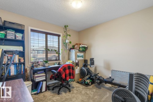 Versatile room featuring a window with blinds, neutral wall paint, textured ceiling, and plush carpet flooring - 7641 Schmid Crescent, Edmonton, AB - Indoor Photo Showing Office