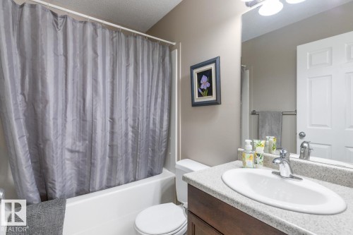 Bathroom featuring a white bathtub, a toilet, and a vanity with an integrated sink - 7641 Schmid Crescent, Edmonton, AB - Indoor Photo Showing Bathroom