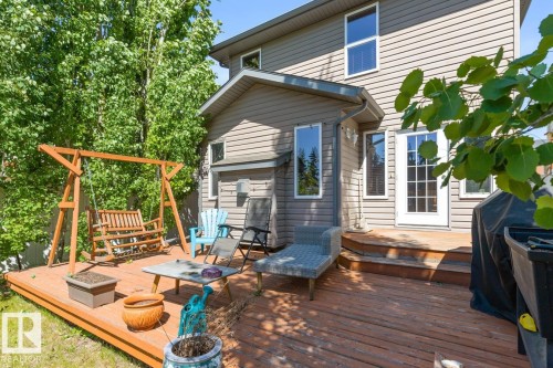 Spacious outdoor deck featuring natural wood-finish flooring, a tiered design, and direct access to the interior via a multi-pane glass door - 7641 Schmid Crescent, Edmonton, AB - Outdoor With Deck Patio Veranda