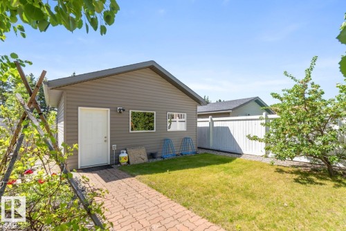 Detached garage with horizontal siding, a white entry door, and two windows - 7641 Schmid Crescent, Edmonton, AB - Outdoor