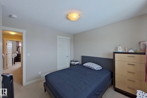 Carpeted room featuring light gray walls, white trim, and a flush-mount ceiling light fixture - 295 401 Southfork, Leduc, AB - Indoor Photo Showing Bedroom