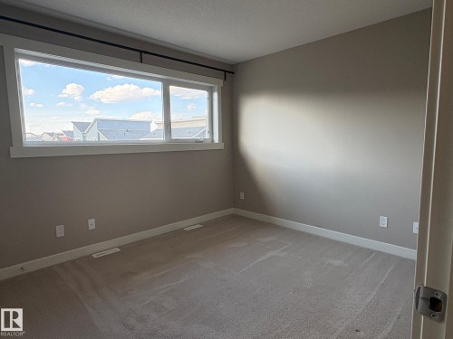 Expansive horizontal window with white trim - 295 401 Southfork, Leduc, AB - Indoor Photo Showing Other Room
