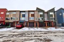 Modern townhome exteriors featuring varied siding materials, attached garages, and covered entryways - 295 401 Southfork, Leduc, AB  - Outdoor With Facade 