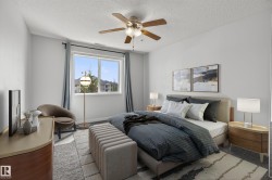 Spacious bedroom featuring light gray walls, a window with a view of residential structures, a ceiling fan with integrated lighting, and carpeted flooring - 