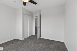 Neutral paint finishes on walls and trim, plush grey carpeting, and a ceiling fan with integrated lighting - 