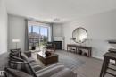 Living area featuring wood-finish flooring, a white fireplace with an arched alcove, and light gray walls - 319 16303 95 Street, Edmonton, AB  - Outdoor With Facade 