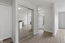 Entryway featuring wood-finish flooring, light grey walls, and a mirrored closet door - 319 16303 95 Street, Edmonton, AB  - Indoor Photo Showing Other Room 