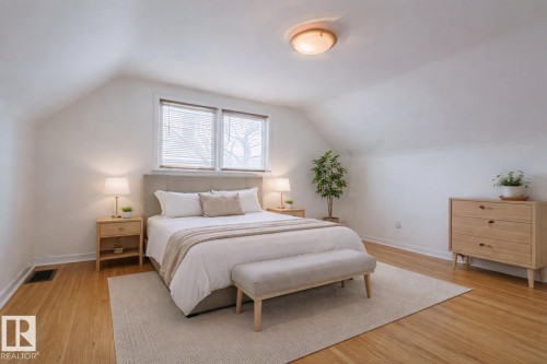 Bedroom with wood-finish flooring, dual windows with blinds, a built-in ceiling light fixture, and sloped ceilings - 11507 72 Avenue, Edmonton, AB - Indoor Photo Showing Bedroom