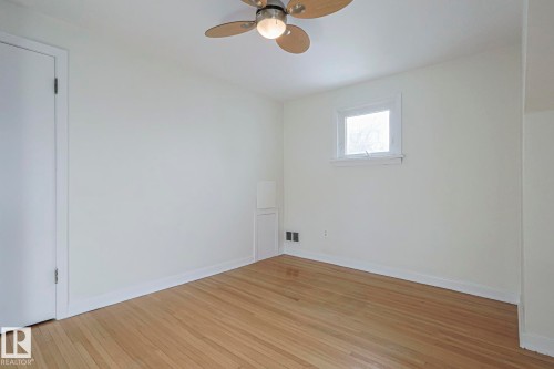 Hardwood flooring, painted walls, single window, flush-mounted ceiling fan with lighting, and white baseboards - 11507 72 Avenue, Edmonton, AB - Indoor Photo Showing Other Room