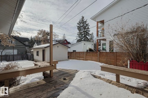 Expansive backyard featuring a wood deck with built-in seating, a detached outbuilding, and wood privacy fencing - 11507 72 Avenue, Edmonton, AB - Outdoor