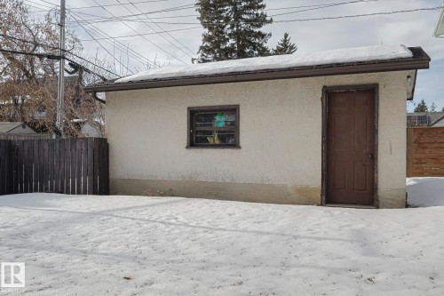 Detached stucco structure featuring a brown entry door and a single window - 11507 72 Avenue, Edmonton, AB - Outdoor
