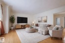 Spacious living area featuring wood-finish flooring, light wall tones, and a wide entryway - 11507 72 Avenue, Edmonton, AB  - Indoor Photo Showing Living Room 