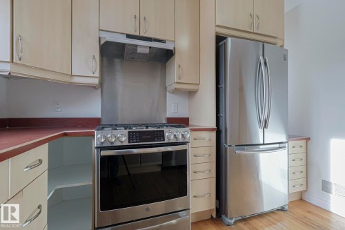 Kitchen featuring stainless steel appliances, including a French door refrigerator and a gas range with an overhead vent - 11507 72 Avenue, Edmonton, AB - Indoor Photo Showing Kitchen