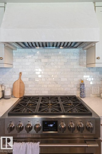 Stainless steel range with six burners and an integrated digital display, complemented by a custom range hood - 12423 28A Avenue, Edmonton, AB - Indoor Photo Showing Kitchen