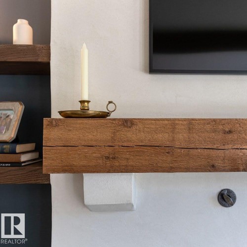 Rustic wood mantelpiece on a textured white wall, featuring integrated support - 12423 28A Avenue, Edmonton, AB - Indoor Photo Showing Other Room