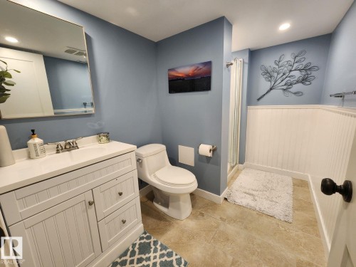 Bathroom featuring a white beadboard vanity with a white countertop and integrated sink, a frameless mirror, and a standing shower with a glass enclosure - 12423 28A Avenue, Edmonton, AB - Indoor Photo Showing Bathroom