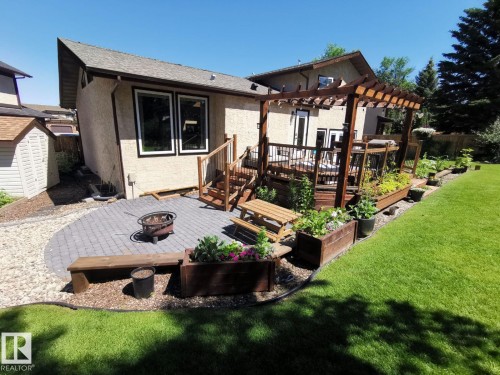 Expansive backyard with a manicured lawn, multi-level wood deck, and a wood pergola - 12423 28A Avenue, Edmonton, AB - Outdoor With Exterior