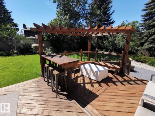 Expansive wooden deck featuring a pergola structure, built-in bar, and integrated seating - 12423 28A Avenue, Edmonton, AB - Outdoor With Deck Patio Veranda