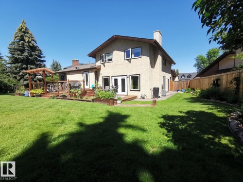 Expansive green lawn bordering a multi-level wood deck with a pergola - 12423 28A Avenue, Edmonton, AB - Outdoor With Deck Patio Veranda