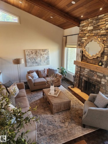 Stacked stone fireplace with a substantial wood mantel - 12423 28A Avenue, Edmonton, AB - Indoor Photo Showing Living Room With Fireplace