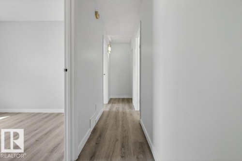 Hallway featuring wood-finish flooring, white baseboards, and light neutral wall paint - 3E Twin Terrace, Edmonton, AB - Indoor Photo Showing Other Room