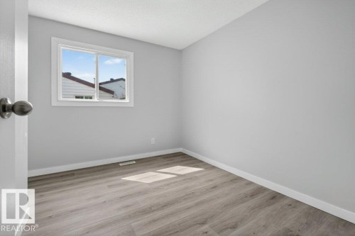 Bright room featuring wood-finish flooring, light grey walls, white trim, and a window providing natural illumination - 3E Twin Terrace, Edmonton, AB - Indoor Photo Showing Other Room
