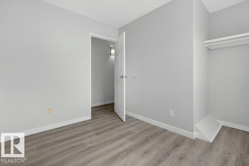 Light gray wall finishes, white trim, and wood-finish flooring - 3E Twin Terrace, Edmonton, AB - Indoor Photo Showing Other Room