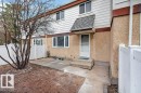 Two-story exterior with textured stucco and horizontal siding, featuring a covered entrance, concrete walkway, and white vinyl fencing - 3E Twin Terrace, Edmonton, AB  - Outdoor 
